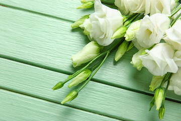 Bouquet of beautiful eustoma flowers on color wooden background, closeup