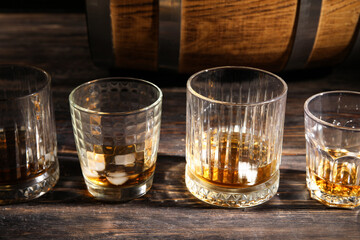 Glasses of cold whiskey on dark wooden background