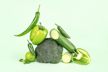 Composition with different fresh green vegetables on color background