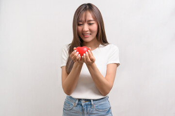 Portrait of young asian woman holding holding red heart shape over white background studio