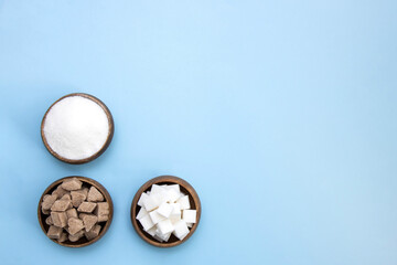 cups with sugar on blue background with copy space