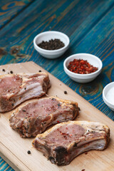 Fresh pork with ingredients for cooking on blue background