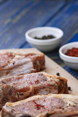 Fresh pork with ingredients for cooking on blue background