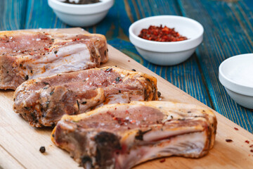 Fresh pork with ingredients for cooking on blue background