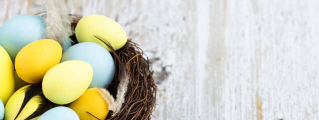 Stylish background with colorful easter eggs on white wooden background with copy space
