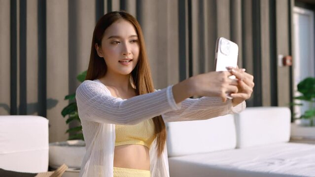 summer leisure casual asia female woman yellow bikini enjoy selfie selfshot photo herself via smartphone asian influencer broadcast lifestyle share experience with her follower on social media