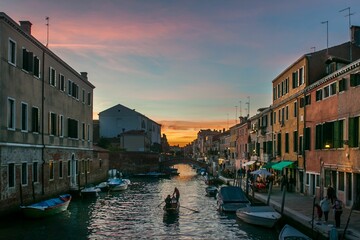 Fototapeta na wymiar Aerial view of canal surrounded by buildings in Venice during sunset