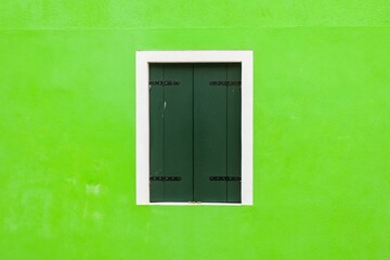 Green window of green wall in Venice