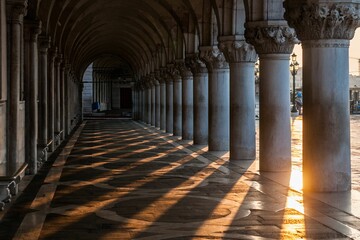 Long hallway of a building with pillars at sunset