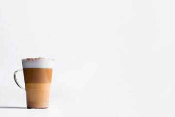 Milk coffee or latte macchiato glass, on white background. Italian coffee with milk and layers. Gourmet coffee.