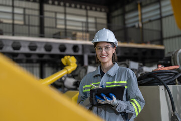 Portrait of engineer woman holding tablet computer checking robot arms machine at assembly robotic warehouse factory