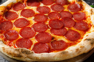 Pepperoni Pizza with Mozzarella Cheese, Salami, Tomato Sauce on Dark Background, Freshly Baked Pizza