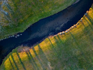 Aerial view over a quiet park with a lake at sunrise