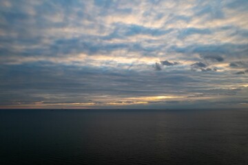 Aerial view of the seascape under cloudy dusk sky at sunset
