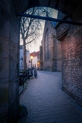 Vertical shot of a narrow alley surrounded by buildings seen during a sunset