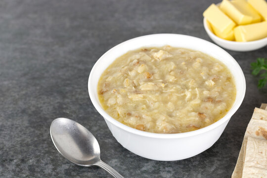 Traditional Armenian porridge - harissa cooked with chicken, wheat, butter and lavash on gray background. 