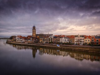 Fototapeta na wymiar Cityscape of the river city Deventer, Netherlands with a view of St Lebuinus church on a cloudy day
