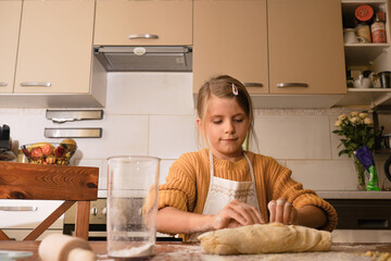 Obraz na płótnie Canvas Girl do the dough in the kitchen. Cooking holiday pie or cookies for Mother's day. Concept of home baking.