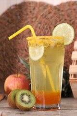 Still life with a refreshing passion fruit-flavored soda decorated with lemon, kiwi, and apple