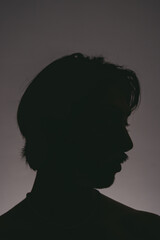 Artistic photo of the silhouette of a young latin man in profile and with mustache on a plain...