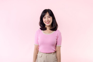 Fototapeta premium Portrait beautiful young asian woman model happy smile in pink sweater casual style fashion isolated on pink studio background. Attractive female person cheerful cute face portrait, Woman day concept.