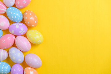 Fototapeta na wymiar Happy easter holiday celebration concept. Group of painted colourful eggs decoration on a yellow background. Seasonal religion tradition design. Top view, flat lay, copy space.