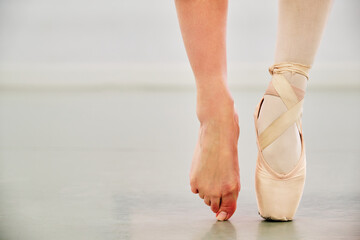 Ballerina legs wearing a pointe shoe on one foot and nothing on the other.