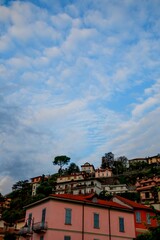 Fototapeta na wymiar Vertical shot of cloudy morning on the buildings of Argegno in Italy