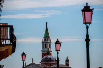 Selective focus of San Giorgio Maggiore with street lamps under blue sky, Venice, Italy