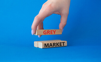 Do grey market. Wooden blocks with words grey market. Beautiful blue background. Businessman hand. Business and grey market concept. Copy space.