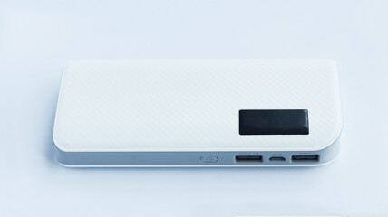 A white flat power bank isolated on white background with two usb output and one input socket electrical source.