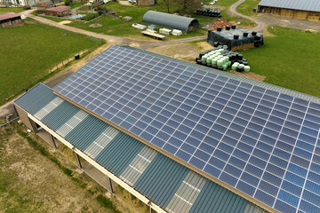 Aerial view of farm building with photovoltaic solar panels mounted on rooftop for producing clean...