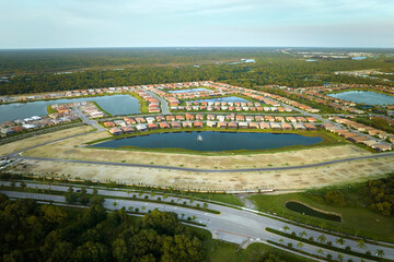 Aerial view of real estate development with tightly located family houses under construction in Florida closed suburban area. Concept of growing american suburbs