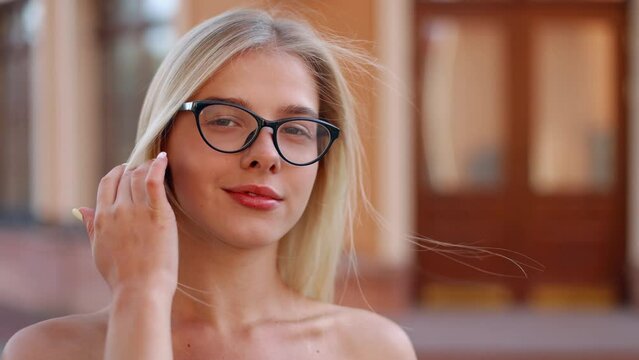 Close Up Face Of Beautiful Blonde Sexy Smiling Woman With Long Hair In Glasses.  Portrait Of A Beautiful Girl, Looking At The Camera, Smiling And Fixing Her Hair