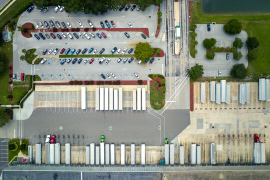 Big corporate shipment center with many cargo semi trucks unloading and uploading retail products for further retail shipment. Global market concept © bilanol
