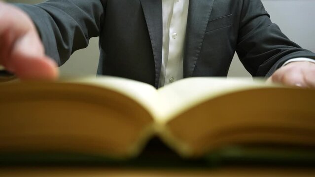 End face of book. Businessman flipping page
