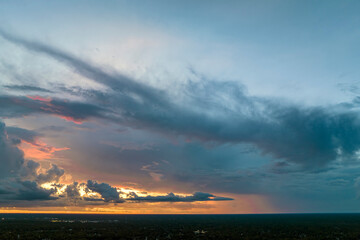 Obraz premium Colofrul clouds brightly illuninated by setting sun on evening sky. Changing cloudscape weather at sunset