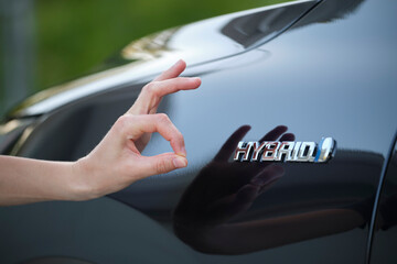Purchaser hand showing thumb up sign at hybrid car new effective vehicle - obrazy, fototapety, plakaty