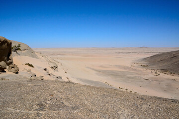 Fototapeta na wymiar Waterless desert valley to the horizon against the background of the blue sky. Climate change and global warming