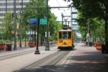 A yellow electric trolley on Main Street in downtown Memphis, Tennessee in summer