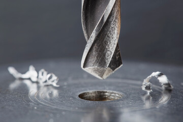 metal drill bit make holes in steel billet on industrial drilling machine. Metal work industry....