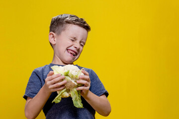 A charming little boy refusing to eat cauliflower. Healthy food