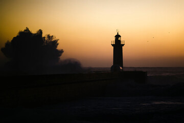 A huge wave at the lighthouse at dusk. Atlantic, Portugal.