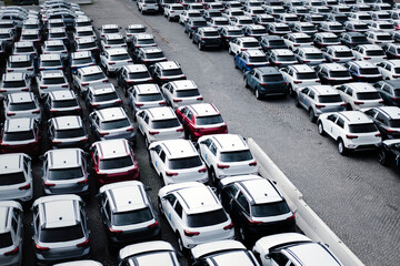 A parking lot with many new cars. An aerial view of an open-air parking lot.
