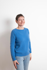 Paris, France - 03 18 2023: Studio shot of a mature woman with short hair posing and wearing a blue sweater with cufflinks