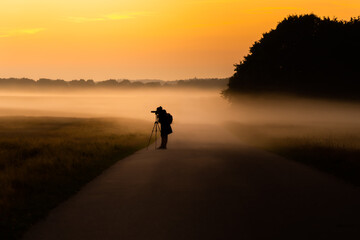 Fototapeta na wymiar silhouette of a photographer in the sunset