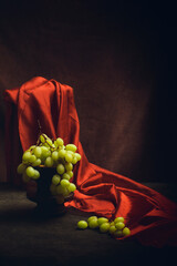 Still life with grapes and red cloth