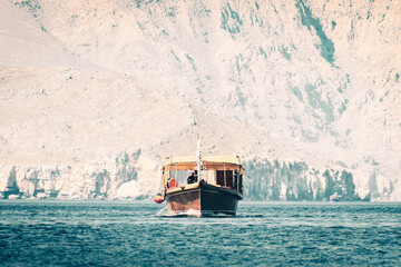 Traditional tour boat on water on cruise in persian gulf. Oman travel famous leisure activities