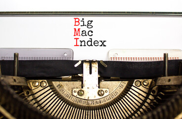 BMI big mac index symbol. Concept words BMI big mac index typed on retro old typewriter on a beautiful white paper background. Business and BMI big mac index concept. Copy space.