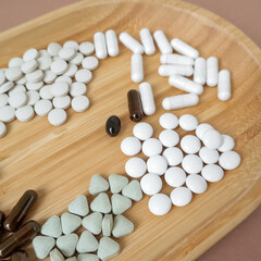 White pills on a wooden board on a white background. Top view. Place for text. Medicine, health, beauty. High quality photo